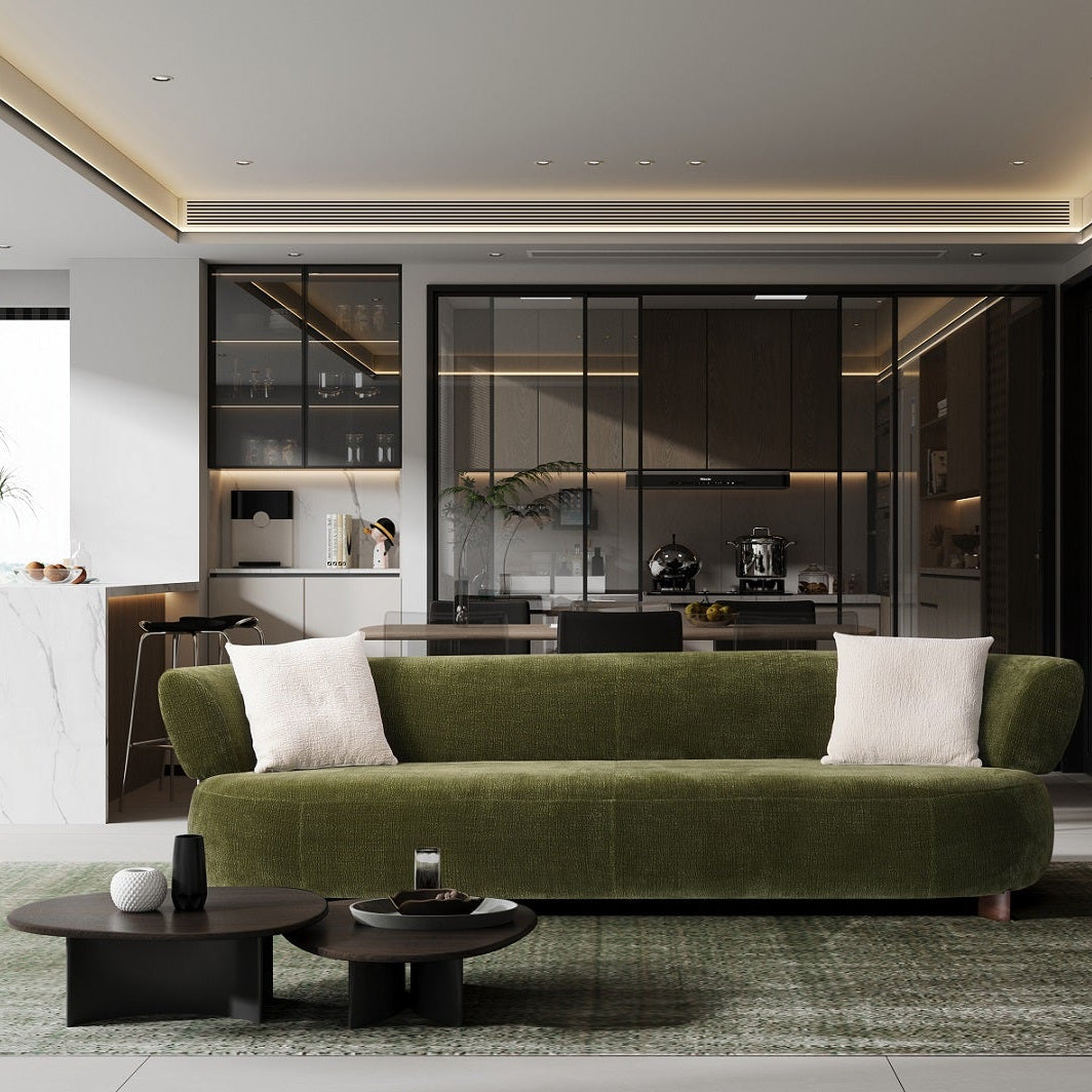 Modern living room with a green sofa, coffee table, and decorative items.